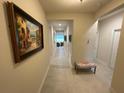 Hallway featuring tile flooring, neutral walls, and decorative artwork at 4428 Conchfish Ln, Osprey, FL 34229