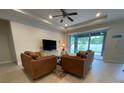 Comfortable living room featuring tile floors, two sofas, and sliding glass doors at 4428 Conchfish Ln, Osprey, FL 34229