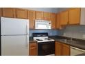 Functional kitchen featuring wooden cabinets, essential appliances, and ample counter space at 4802 51St W St # 1313, Bradenton, FL 34210