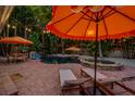 Outdoor oasis boasts a pool, spa, lounge chairs, and dining area under festive string lights and umbrellas at 522 31St W St, Bradenton, FL 34205