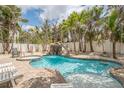 Backyard swimming pool with a waterfall, a slide, and a hot tub surrounded by lush greenery at 538 Canal Rd, Sarasota, FL 34242