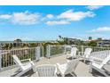 Beautiful rooftop deck with white lounge furniture, ocean view, and metal railing at 538 Canal Rd, Sarasota, FL 34242