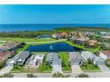 Stunning aerial view of homes surrounding a pond with ocean view in the distance at 5428 Title Row Dr, Bradenton, FL 34210