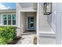 Inviting front door with modern design and tiled entrance, surrounded by green shrubs at 5428 Title Row Dr, Bradenton, FL 34210