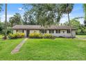 Charming single-story home featuring a well-manicured lawn and mature trees enhancing its curb appeal at 5430 Richardson Rd, Sarasota, FL 34232