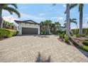 Stunning single-story home featuring a gray garage door, lovely landscaping, and a spacious brick driveway at 5569 Cape Leyte Dr, Sarasota, FL 34242
