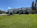 Charming single-story home with a manicured lawn, a lush garden, and an attached two-car garage at 620 Camellia Ave, Ellenton, FL 34222