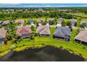 An aerial view shows homes in a suburban neighborhood next to a lake and lush green spaces at 773 Rosemary Cir, Bradenton, FL 34212