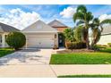 Inviting single-story home featuring a well-manicured lawn, two-car garage, and decorative front yard landscaping at 7750 Ridgelake Cir, Bradenton, FL 34203
