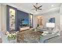 Comfortable living room area, accentuated by a striking blue accent wall and built-in shelving at 7983 Sandstar Way, Sarasota, FL 34240