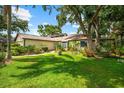 Beautiful home with a well-manicured lawn and mature trees providing ample shade and curb appeal at 8240 Cypress Lake Dr, Sarasota, FL 34243