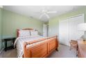 A serene bedroom offers light green walls, a ceiling fan, closet space, and a comfortable atmosphere at 1299 Tripoli, North Port, FL 34286