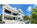 Striking modern home boasts clean lines, outdoor living space with pool, and lush tropical landscaping at 1610 N Lodge Dr, Sarasota, FL 34239