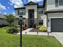 Beautiful two-story home with manicured landscaping, stone accents, and a charming front entrance at 16231 Tradewind Ter, Bradenton, FL 34211