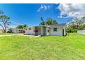 Well-manicured lawn surrounds this cozy home with a screened porch and neatly maintained exterior at 2026 Arkansas Ave, Englewood, FL 34224