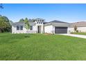 Lovely single-story home featuring a lush green lawn and inviting curb appeal on a sunny day at 2219 Arnet St, Port Charlotte, FL 33948