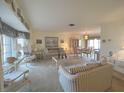 Cozy living room featuring neutral walls, neutral carpeting, and views of the adjacent dining room at 22321 Yonkers Ave, Port Charlotte, FL 33952