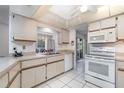 Functional kitchen featuring white appliances, tiled flooring, and ample counter space at 22434 Walton Ave, Port Charlotte, FL 33952