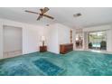 Spacious living room with carpet, slider door to pool, and view to the kitchen and dining room at 22434 Walton Ave, Port Charlotte, FL 33952