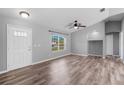 Well-lit living room featuring wood-look floors, white walls, and a large window at 2405 Mistleto Ln, North Port, FL 34286