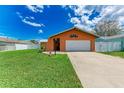 A bright house featuring a beautiful lawn, crisp white fence, and a convenient one-car garage at 2406 15Th W St, Palmetto, FL 34221
