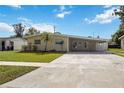 Inviting single-story home with a long driveway and a beautifully manicured lawn at 3641 Stokes Dr, Sarasota, FL 34232
