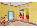 Spacious yellow living room with tiled floors, red carpet, chandelier, and decorative display case at 4105 37Th E St, Bradenton, FL 34208