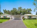 A cozy home features a covered parking area and lush green lawns under a bright, clear sky at 4203 Schwalbe Dr # 115, Sarasota, FL 34235