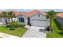 Beautiful single-story home with well-manicured lawn, landscaping, tile roof, and paver driveway at 491 Daylily Blvd, Nokomis, FL 34275