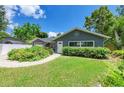 Delightful gray single-story home with inviting front yard, trimmed bushes, and brick pathway at 5415 13Th Avenue W Dr, Bradenton, FL 34209