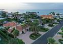 Breathtaking aerial view of a waterfront community with stunning homes, lush landscaping, and canal access to the open bay at 571 Birdie Ln, Longboat Key, FL 34228