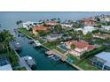 Gorgeous aerial view of waterfront homes with docks, boats, lush landscaping, and sparkling canals leading to the open bay at 571 Birdie Ln, Longboat Key, FL 34228