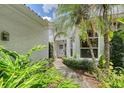 Property's front entrance with tropical landscaping flanking the walkway at 5803 Garden Lakes Palm, Bradenton, FL 34203