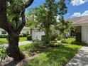 Attractive home with a tile roof, lush landscaping, and a concrete driveway leading to a garage at 5803 Garden Lakes Palm, Bradenton, FL 34203