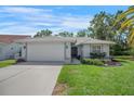 Charming single-story home featuring a well-manicured lawn, tile roof, and attached two-car garage at 6065 Marella Ct, Sarasota, FL 34243
