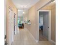 Bright hallway with tiled flooring, a decorative shelf, and an elegant pendant light fixture at 6065 Marella Ct, Sarasota, FL 34243
