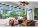 Inviting screened-in lanai area with comfortable seating surrounding a cozy fire pit and mounted television at 616 Dogwood Run, Bradenton, FL 34212