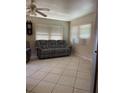 Cozy living room featuring tiled flooring and a comfortable gray sofa set under bright windows at 6803 Washington Pl, Bradenton, FL 34207