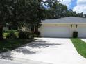 The house has an ample driveway leading to a two car garage and manicured bushes at 7157 Fairway Bend Cir, Sarasota, FL 34243