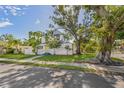 Beautiful house with verdant front yard and mature trees casting shadows on a sunny day at 719 22Nd W St, Bradenton, FL 34205