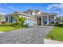 Beautifully landscaped two-story home featuring a blue garage door and brick-paved driveway at 8209 Redonda Loop, Lakewood Ranch, FL 34202