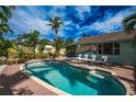 Relaxing backyard with a sparkling pool, lounge chairs, lush tropical landscaping, and a painted exterior wall at 8709 9Th Nw Ave, Bradenton, FL 34209
