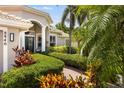 Charming home exterior featuring lush landscaping, a brick walkway, and an inviting entryway at 8840 Brookfield Ter, Bradenton, FL 34212