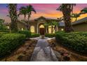 Beautiful home exterior with a brick walkway, lush landscaping, and mature palm trees for a tropical feel at 8999 Wildlife Loop, Sarasota, FL 34238