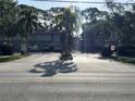 View of the community's gated entrance, surrounded by mature trees and well-maintained landscaping at 900 La Costa Cir # 4, Sarasota, FL 34237