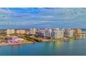 This aerial view showcases the luxurious condo building surrounded by water and the vibrant cityscape at 990 Blvd Of The Arts # 801, Sarasota, FL 34236