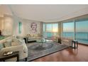 Bright living room featuring floor-to-ceiling windows with water views and elegant contemporary furniture at 990 Blvd Of The Arts # 801, Sarasota, FL 34236