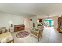 Spacious living room with tile flooring, vintage furniture, and an archway to the dining room at 10095 Nassau Ct, Seminole, FL 33776
