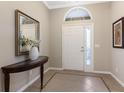 Elegant foyer with tile flooring, a decorative table, and a stylish mirror creating a warm and inviting entrance at 11610 Griffith Park Ter, Bradenton, FL 34211