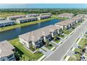 Community aerial of townhomes surrounding a serene lake; lush landscaping adds to the appeal at 15164 Sunny Day Dr, Bradenton, FL 34211